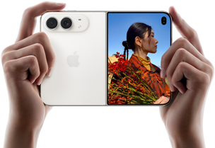 iPhone Duo, Star White color, held by two hands in horizontal orientation, unfolded, left panel shows 48MP Dual Fusion rear cameras, right panel shows person getting their picture taken on outer display, the subject of the photo is able to see their face as their picture is getting taken using Duo Preview