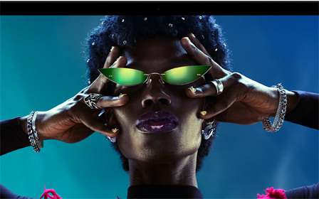 Colorful screen on a MacBook Pro of a person crowd-surfing at a party, showcasing the vibrant Liquid Retina XDR display