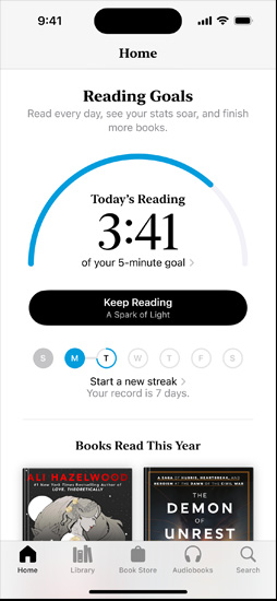 iPhone screen showing the Reading Goals interface in the Books app. At the top, there is a progress ring. Below the progress ring is the weekly reading streak tracker. At the bottom is the Books Read This Year section, which includes a row of two books, with an empty slot for a third